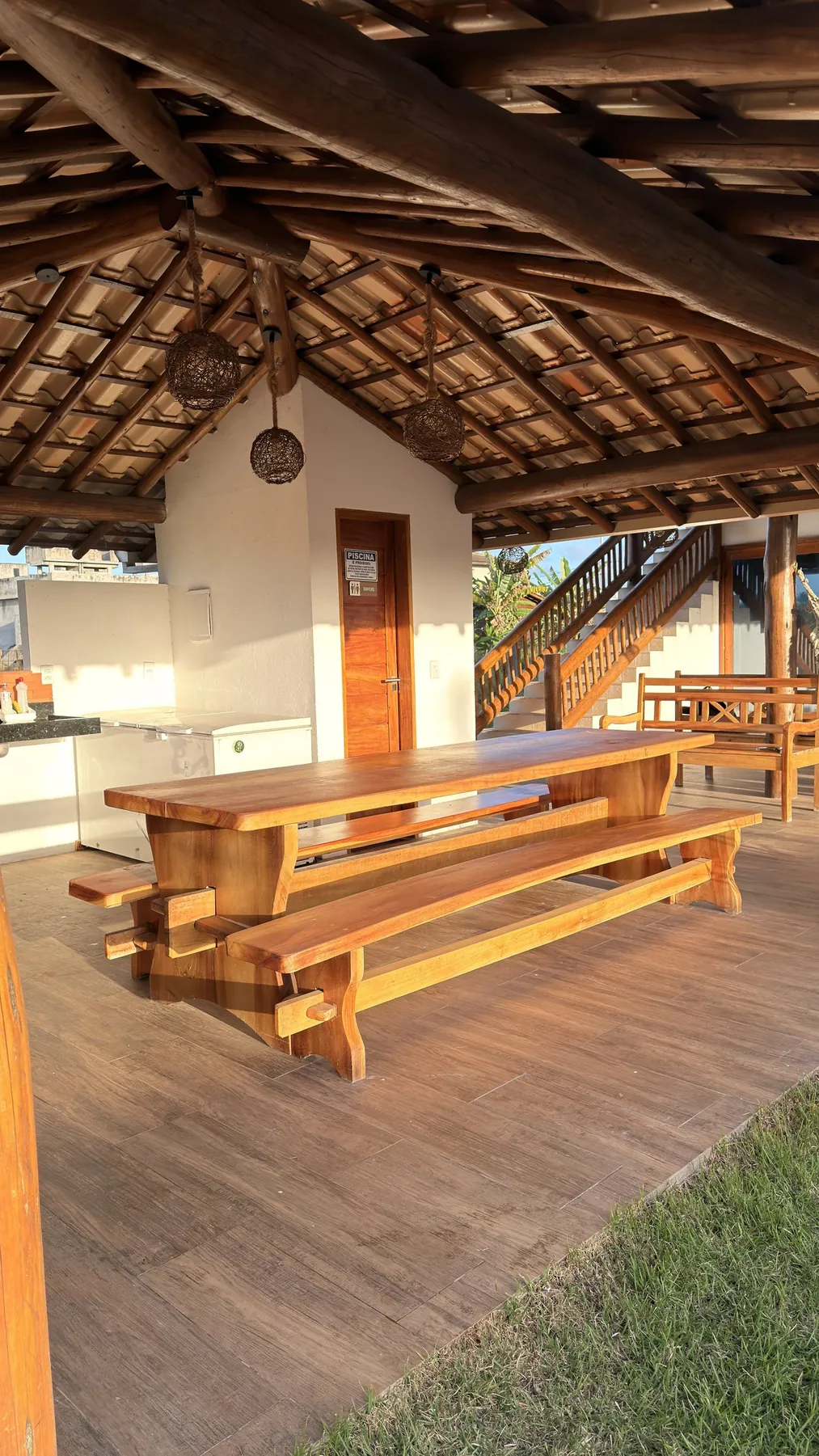 Mesa de madeira maciça sob o telhado da área de lazer