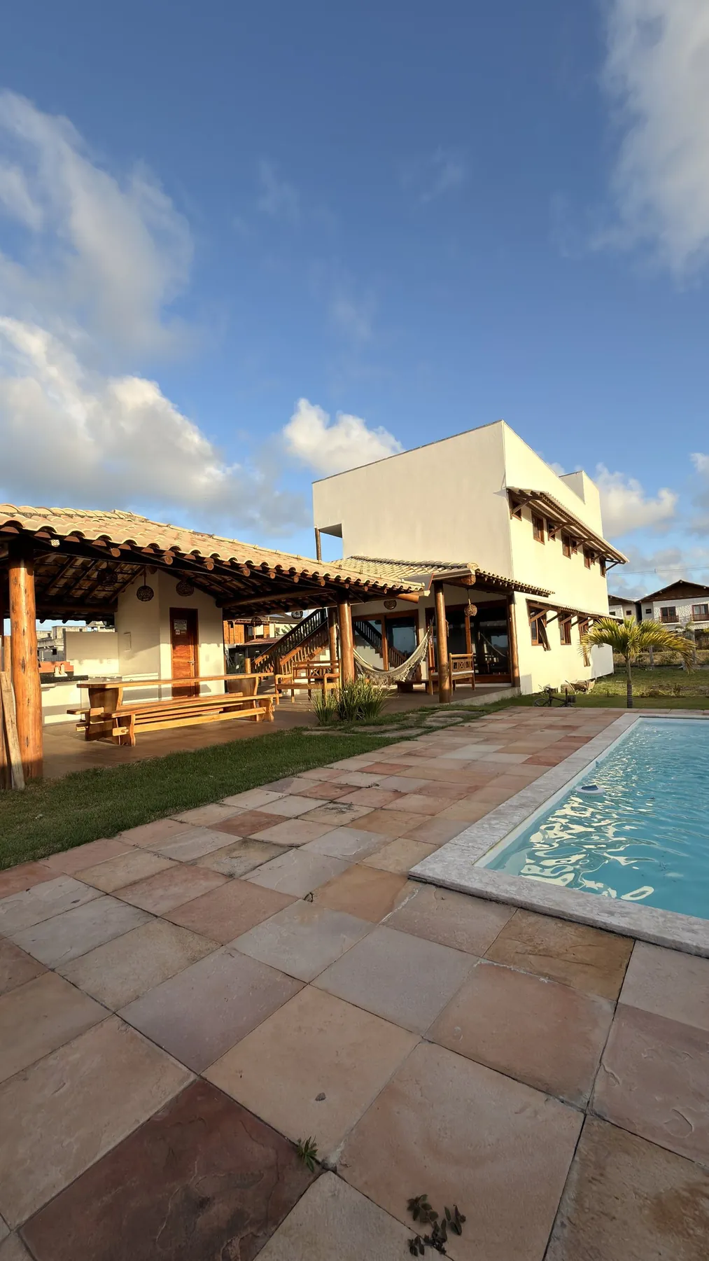 Borda da piscina e o deck de pedra sob o céu azul