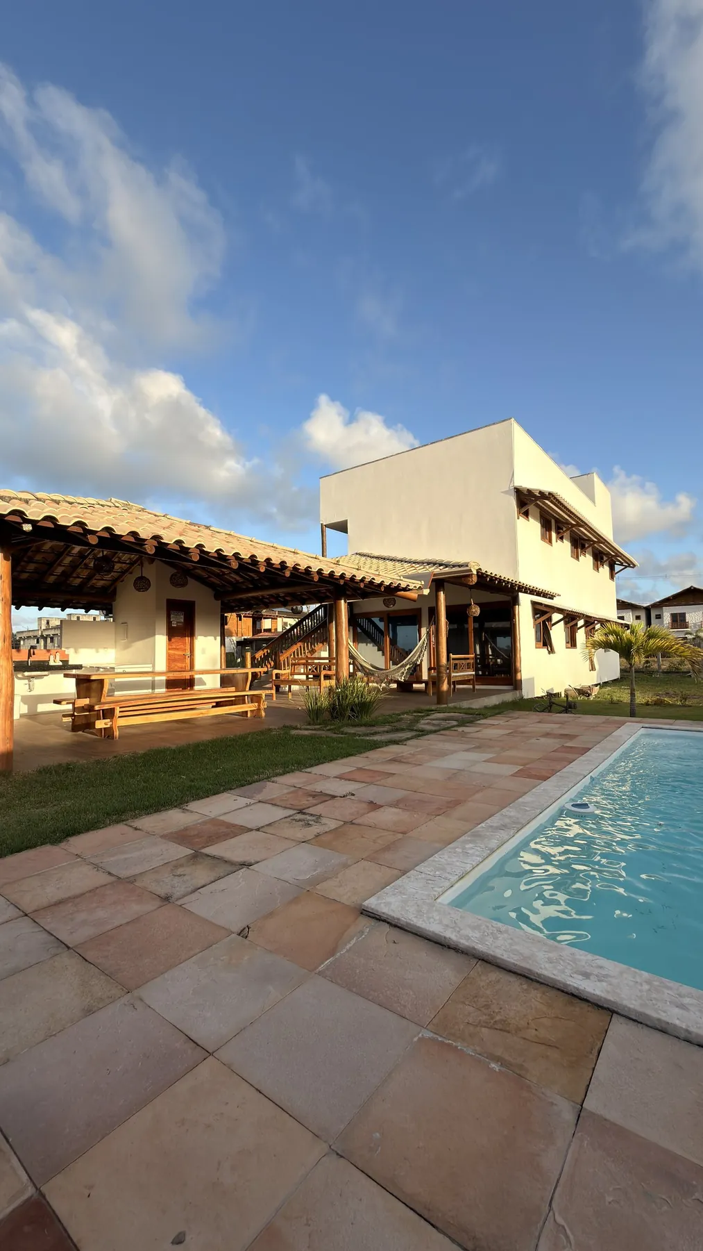 Casa Luz vista do jardim, com a piscina em primeiro plano e o céu azul de Barra Grande
